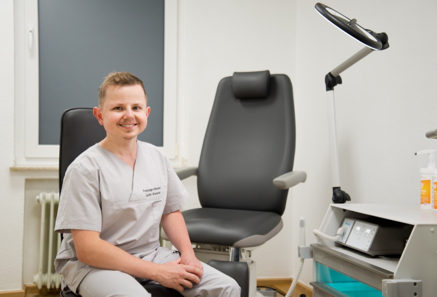 Justin Wieseler in seiner Podologiepraxis in Oberhausen-Schmachtendorf, neben dem Behandlungsstuhl